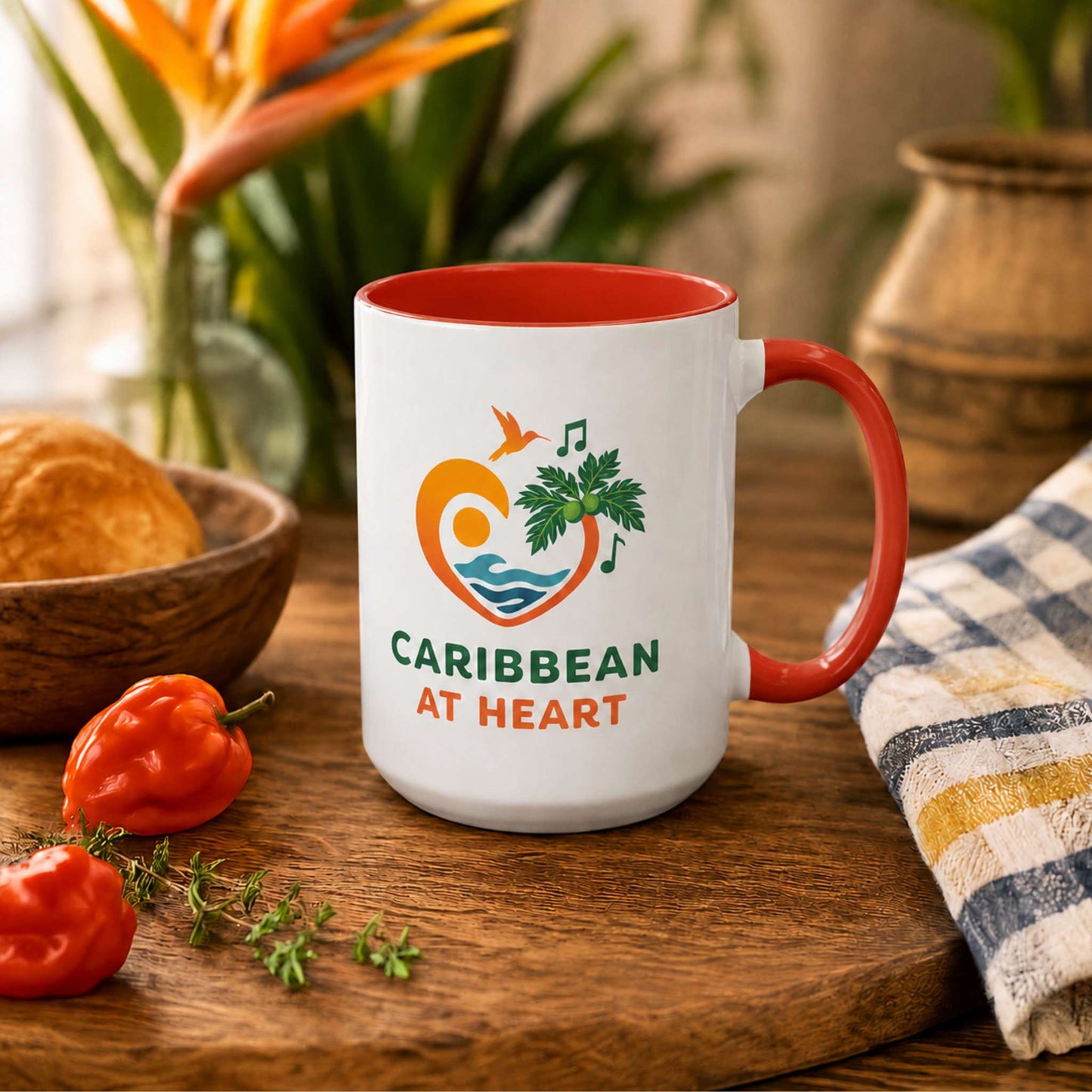 Caribbean At Heart logo accent mug with red handle and interior featuring heart, hummingbird, waves and breadfruit leaves.