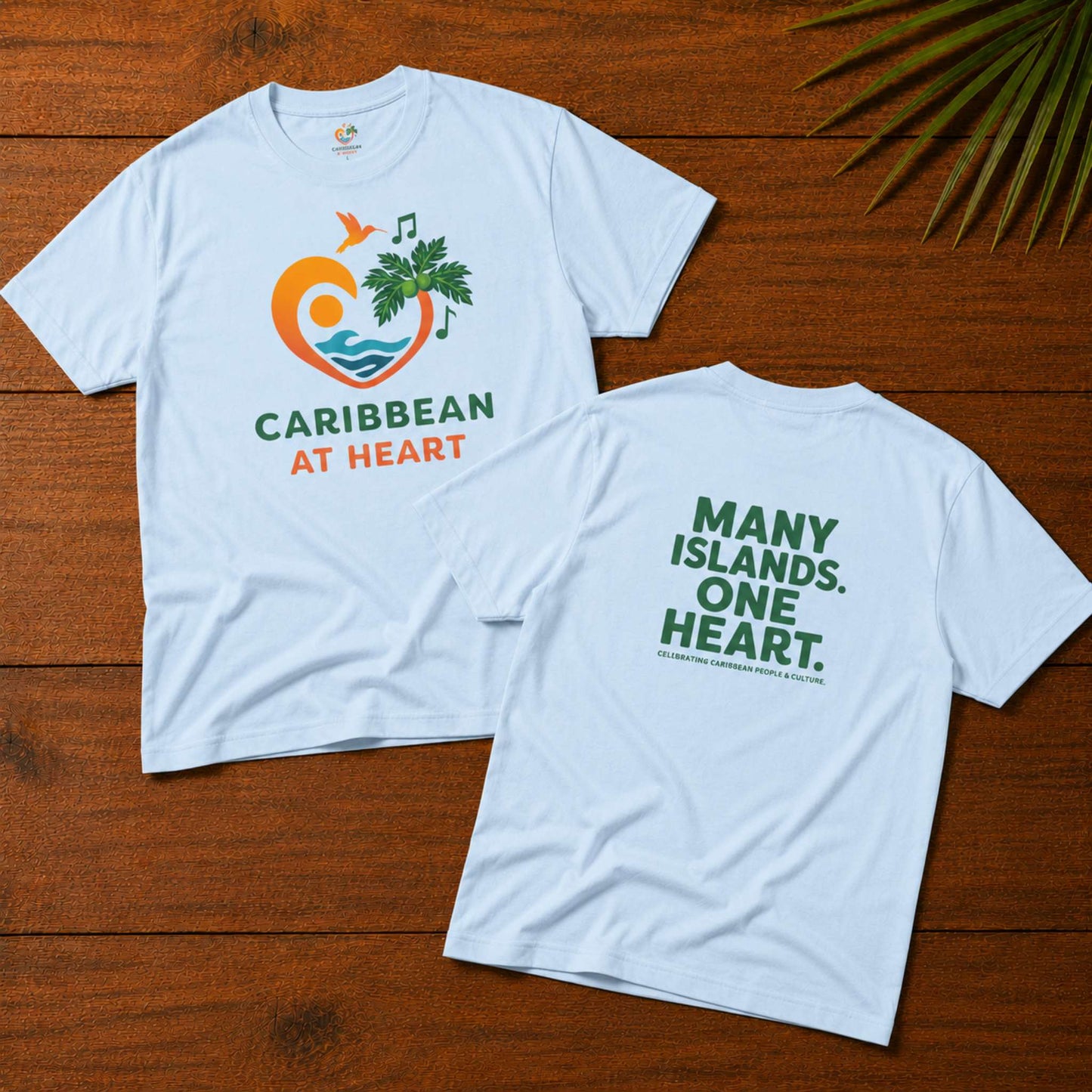 Adult unisex Caribbean graphic t-shirt featuring the Caribbean At Heart logo on the front and Many Islands One Heart artwork on the back.