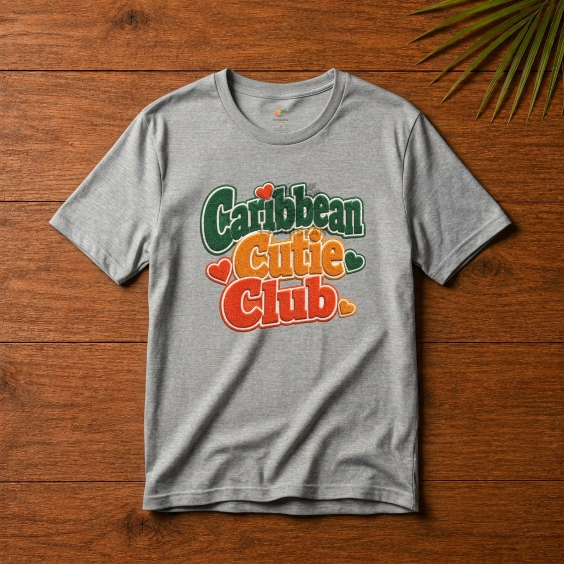 Youth shirt with Caribbean Cutie Club graphic in colorful retro lettering and heart accents.