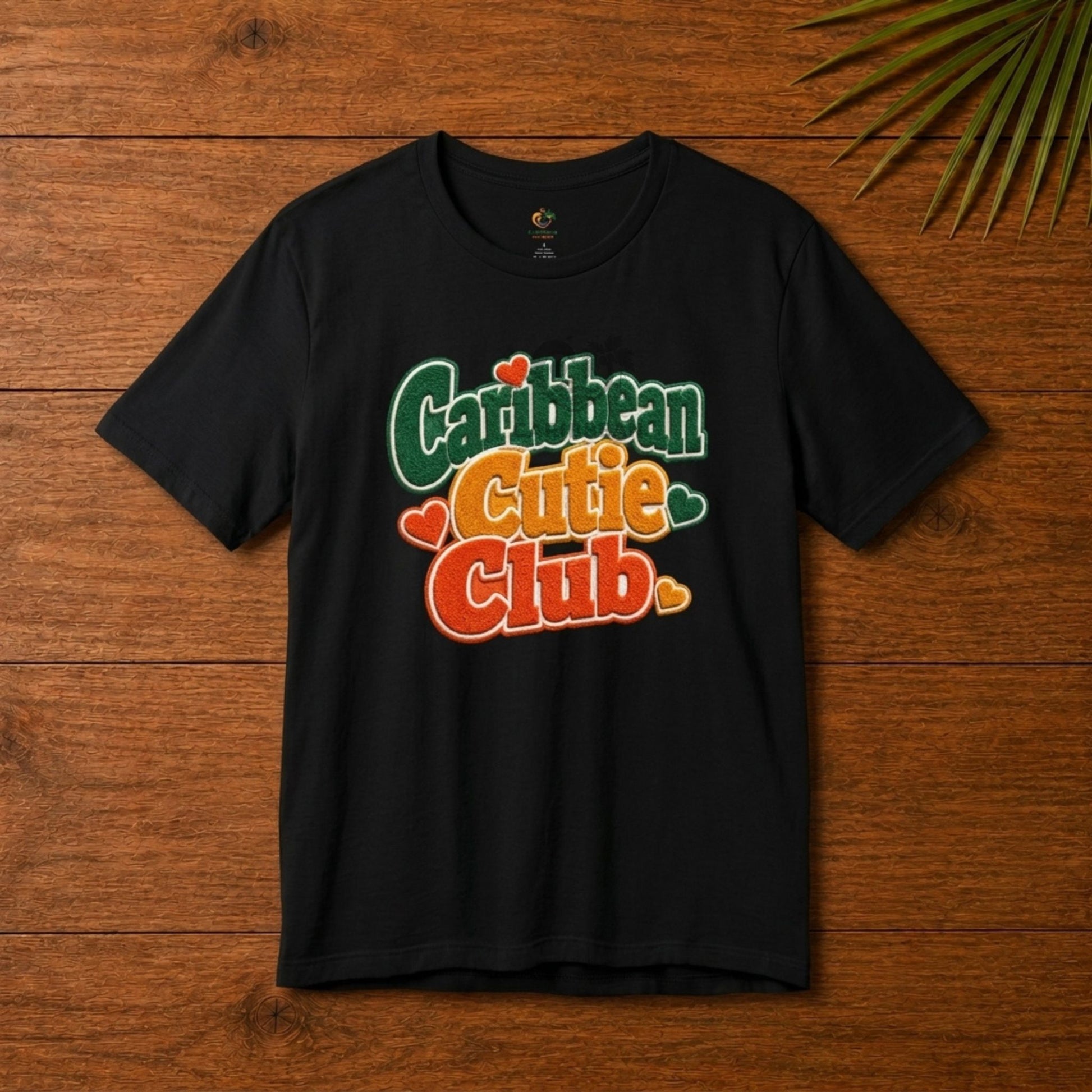 Youth shirt with Caribbean Cutie Club graphic in colorful retro lettering and heart accents.