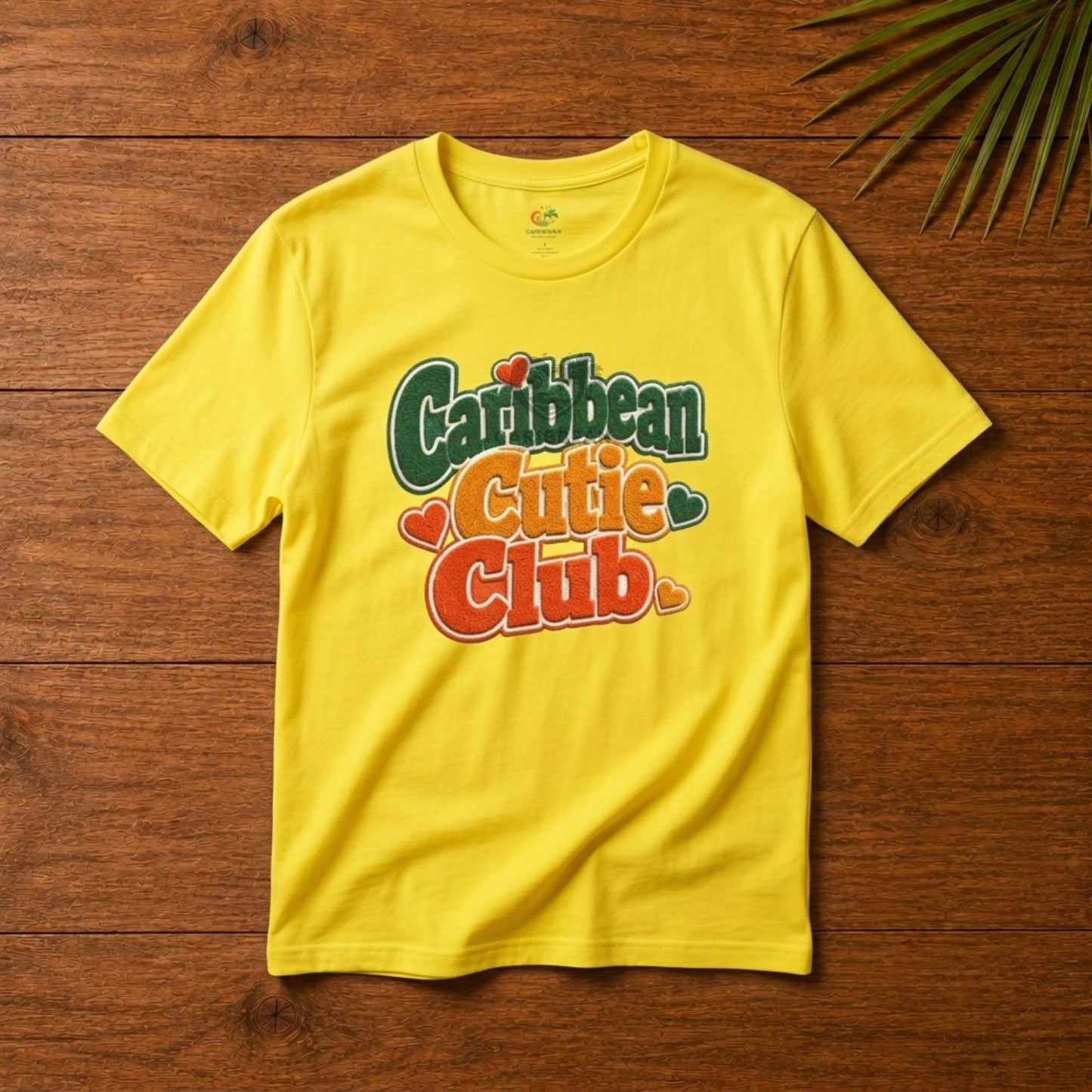Youth shirt with Caribbean Cutie Club graphic in colorful retro lettering and heart accents.