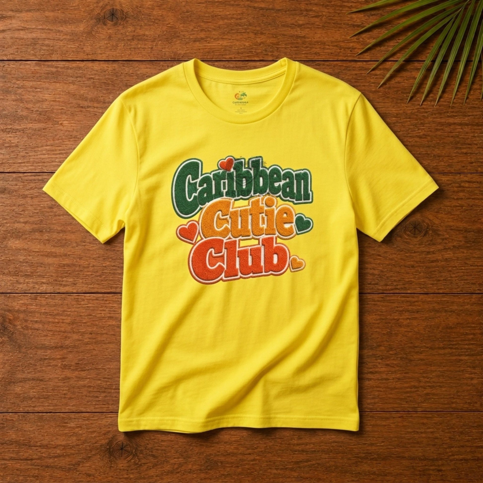 Youth shirt with Caribbean Cutie Club graphic in colorful retro lettering and heart accents.