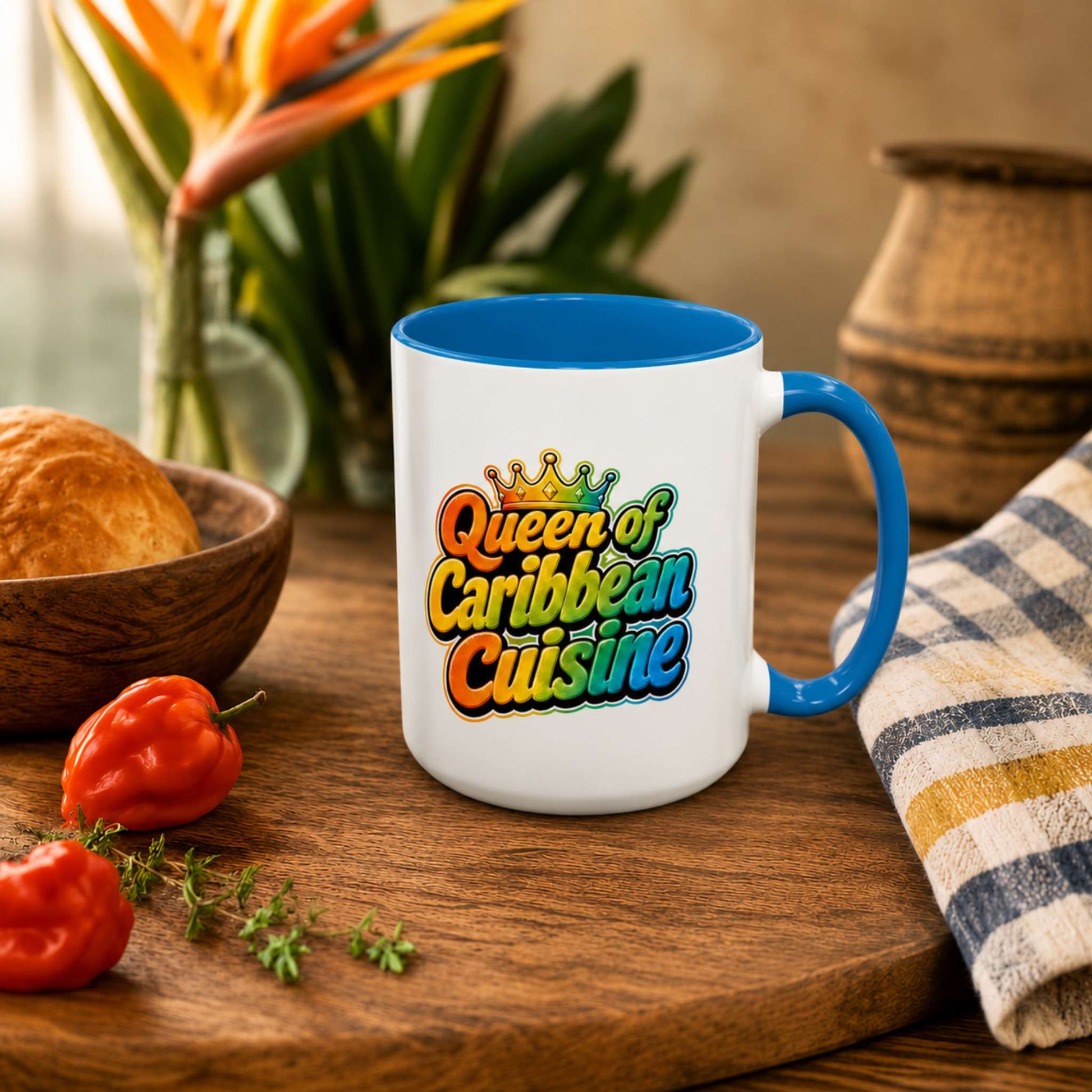 Queen of Caribbean Cuisine accent mug with colorful crown graphic and blue handle and interior.