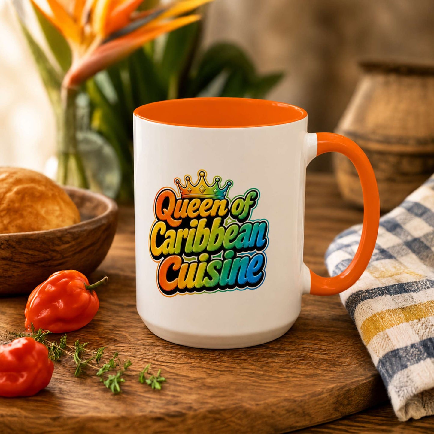 Queen of Caribbean Cuisine accent mug with colorful crown graphic and orange handle and interior.