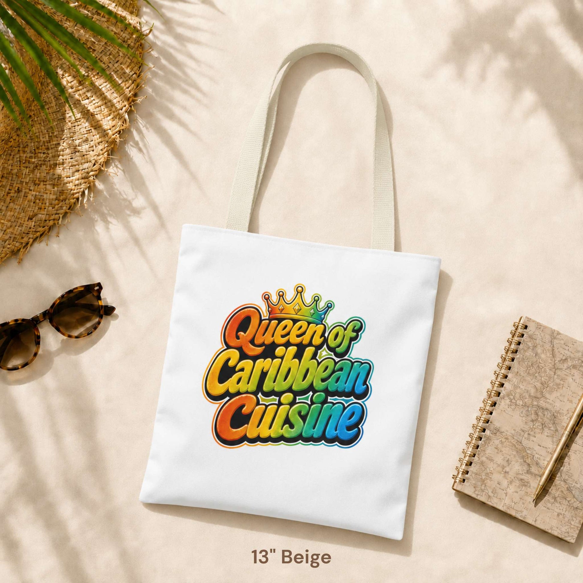 Queen of Caribbean Cuisine tote bag with colorful crown graphic and beige shoulder handles, available in three sizes.