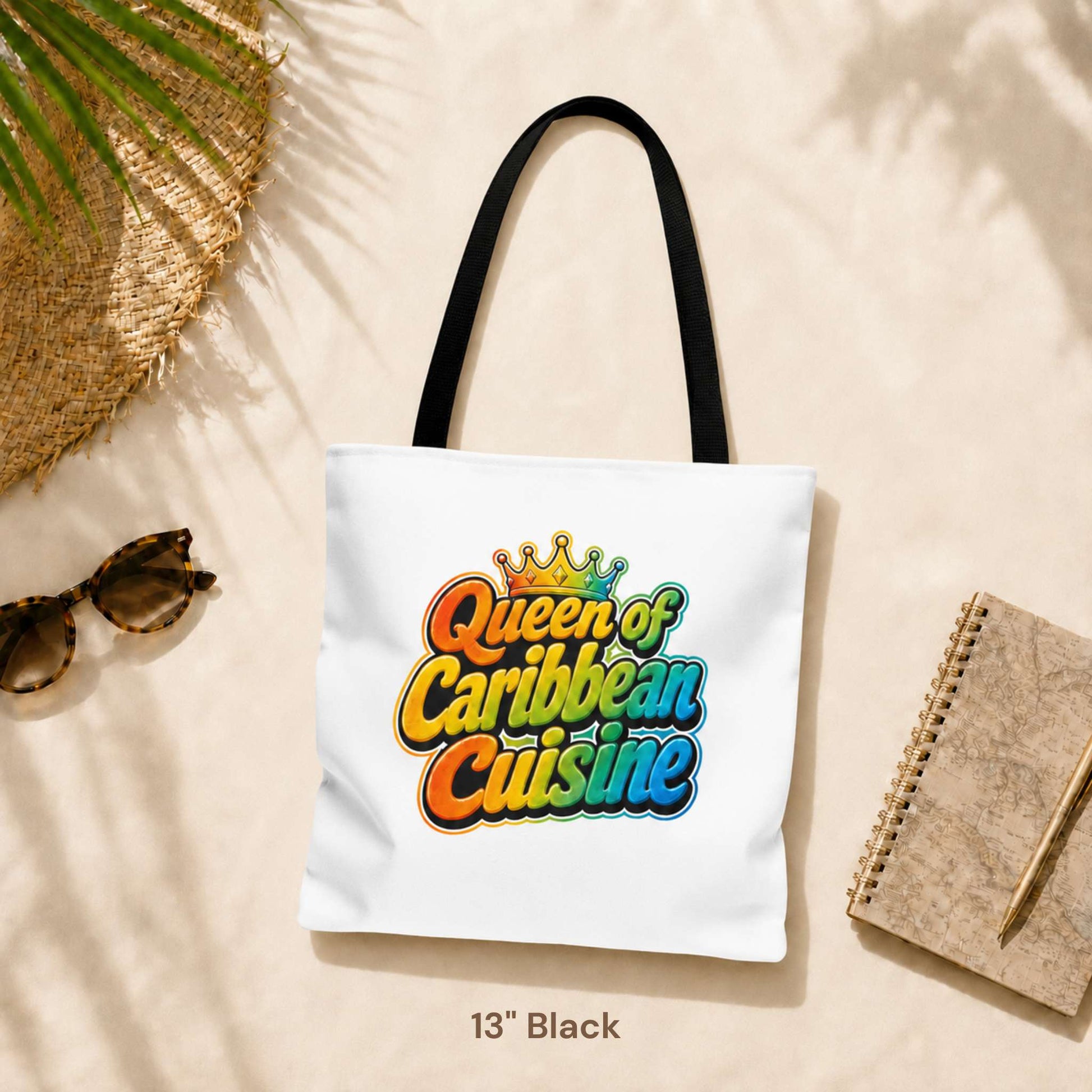 Queen of Caribbean Cuisine tote bag with colorful crown graphic and black shoulder handles, available in three sizes.