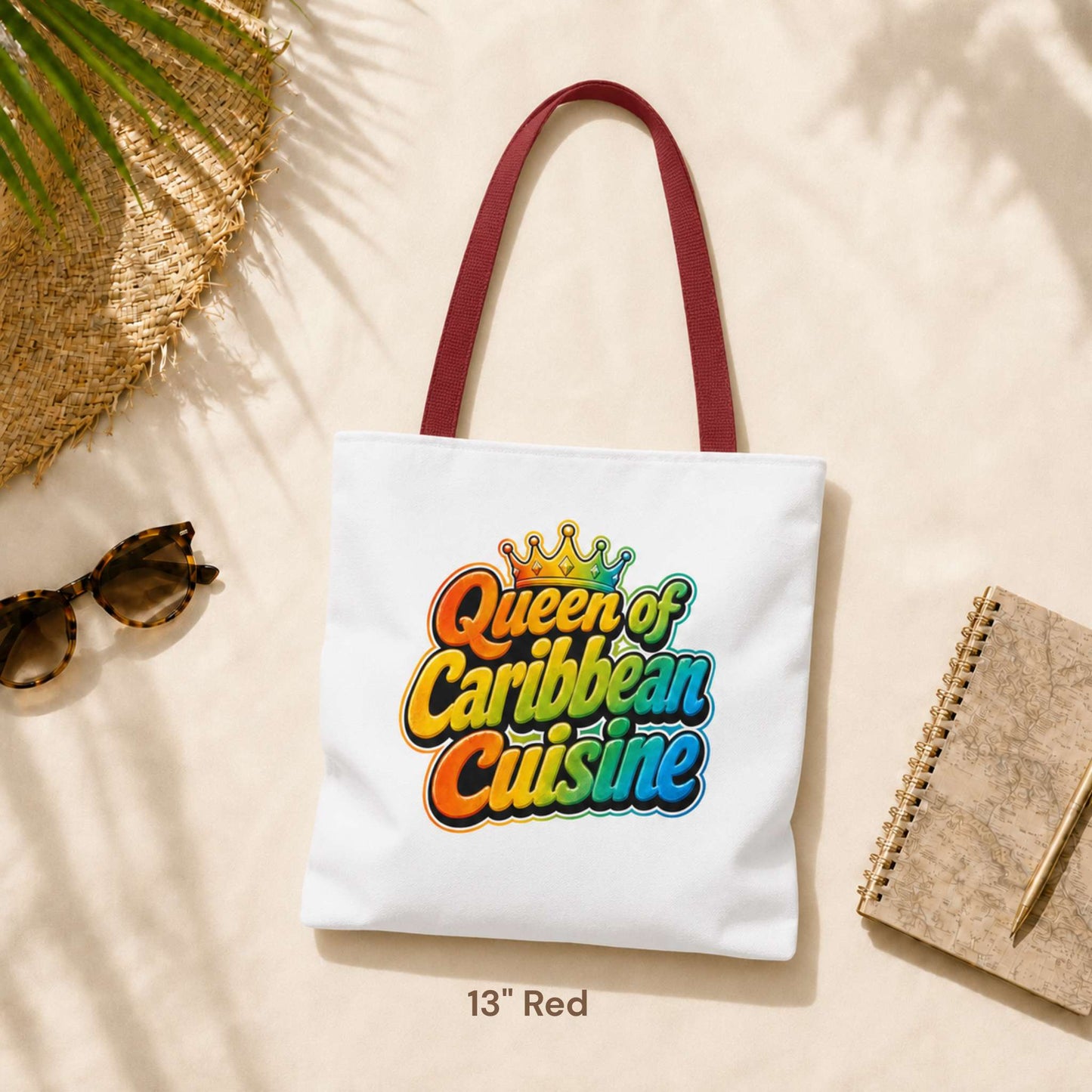 Queen of Caribbean Cuisine tote bag with colorful crown graphic and red shoulder handles, available in three sizes.