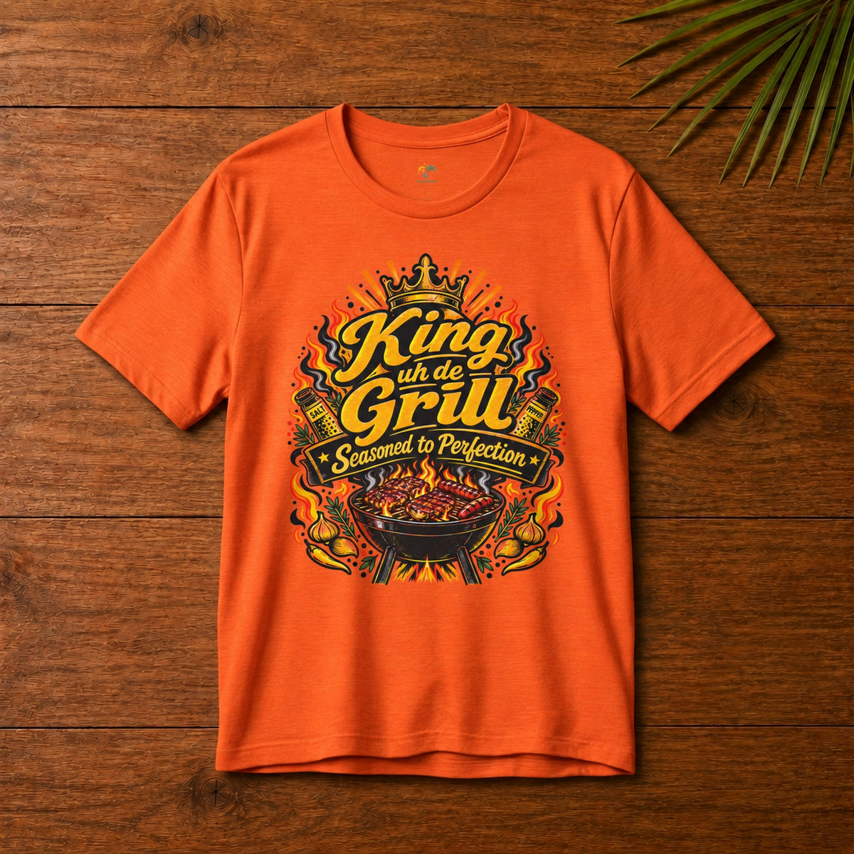King uh de Grill Adult T-Shirt in orange with Seasoned to Perfection grill graphic.